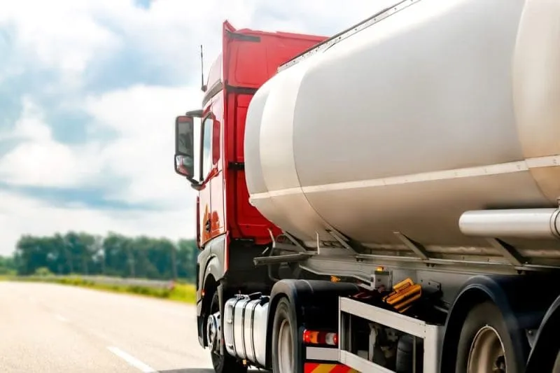 Red tanker truck transporting fuel, supporting a case study on cost efficiency and capability growth in the energy sector.